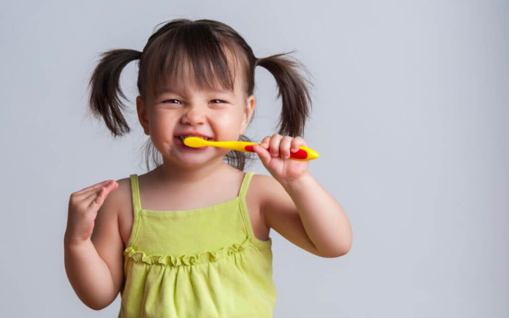 kid brushing her teeth