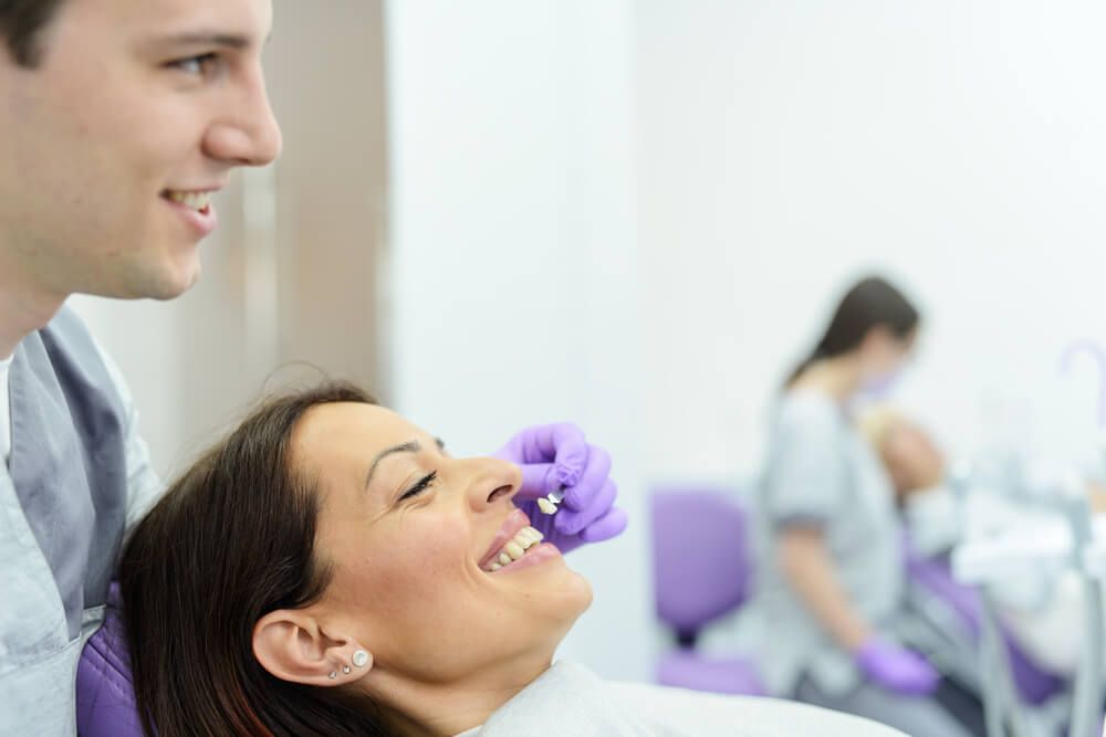 Female patient having veneer placed by male dentist
