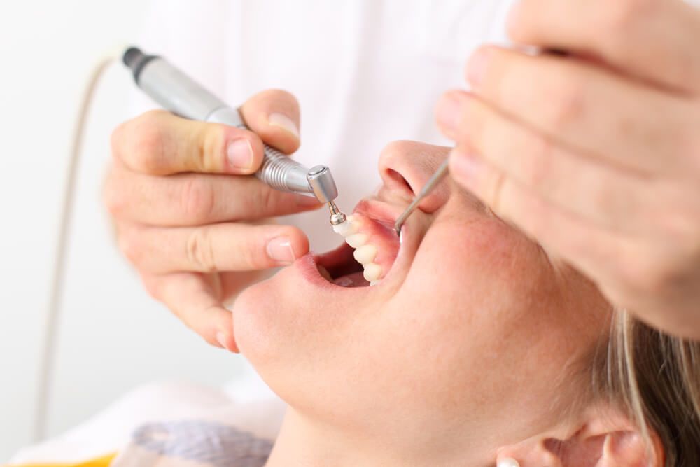 Patient having teeth cleaned by dentist