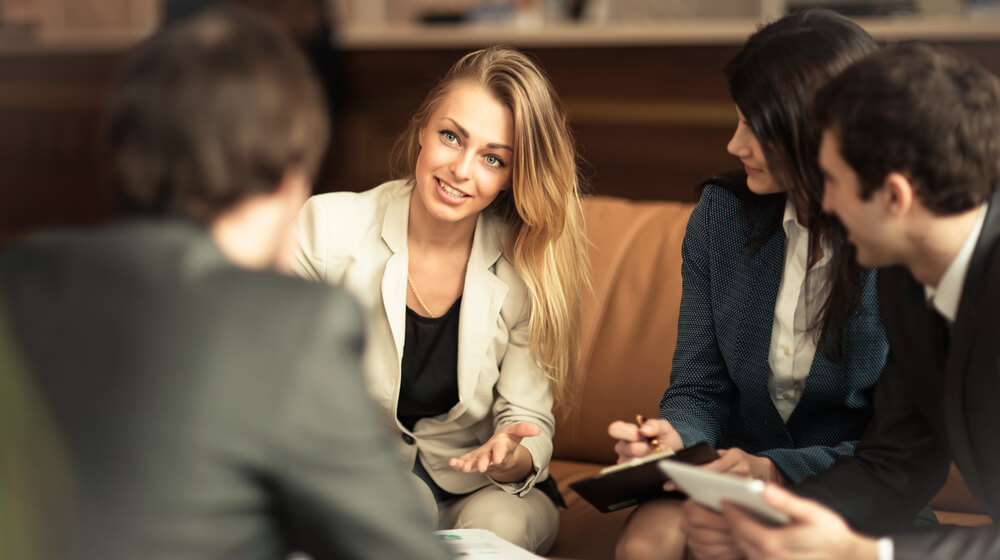 Woman at job interview smiling at small group of interviewers