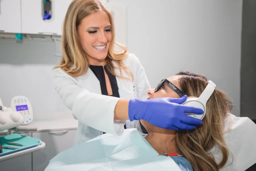 Dr. Lauren Jacobsen assisting a relaxed patient with headphones during a comfort-focused visit at Toothbar in Austin